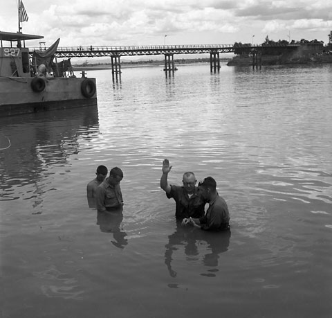 Lt. Harry T. Jones, Chaplain of 1/9 in the 3rd Marine Div., baptizes three men in the Song Bo Dien River, May 7, 1967. USMC Photo:Kronenberg