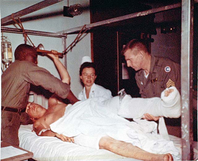 Capt. Norma E. Small and her wardmaster turn a patient in a hip spike cast at the 8th Field Hospital in Nha Trang, February 1966